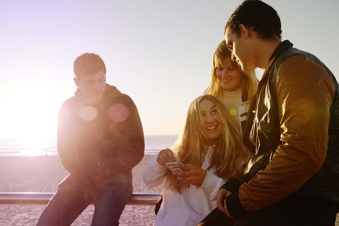 Four teenagers chatting together at the beach
